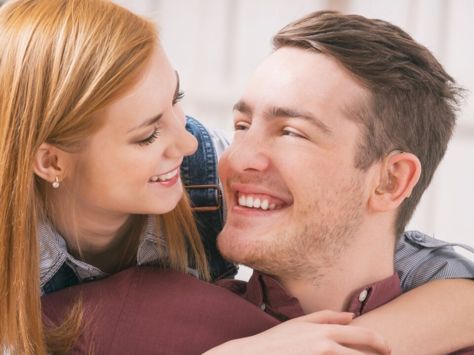 Coppia felice con apparecchi acustici